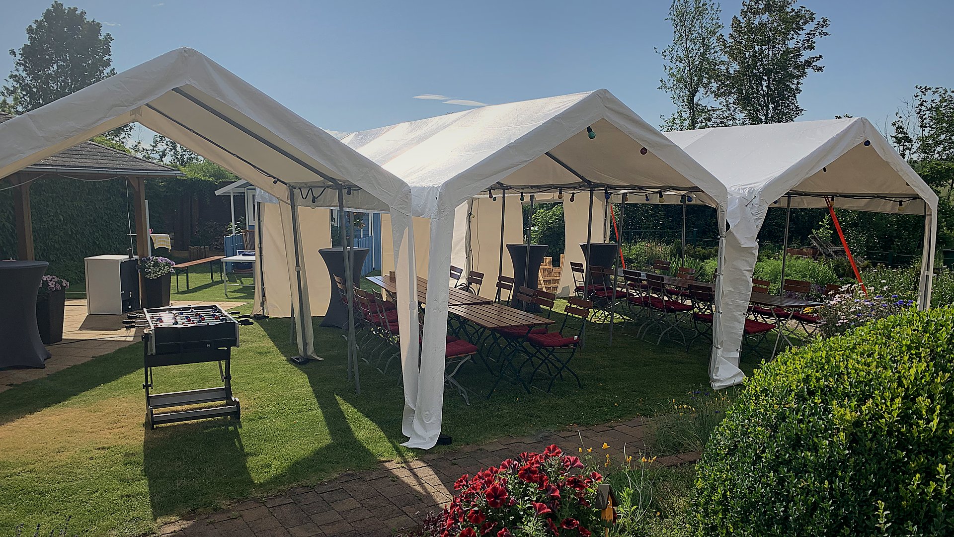 Zwei Partyzelte im Garten bei einer Feier